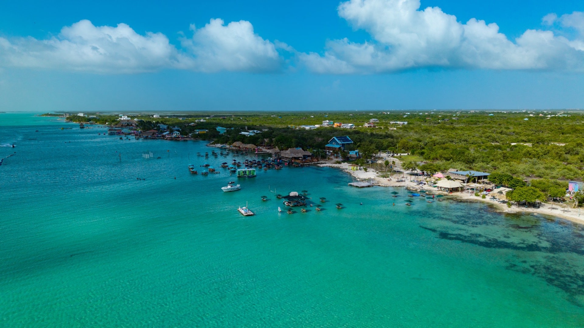 Aerial view of turquoise water and beach clubs along Secret Beach, Ambergris Caye